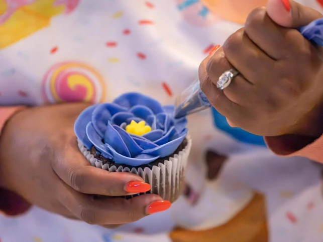 Piping buttercream flowers at a luxury home bakery in Iowa